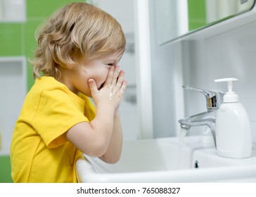 Child Boy Washing His Face In The Bathroom.