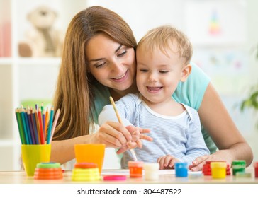 Child Boy And Woman Painting In Daycare Or Nursery Or Playschool