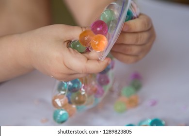 Child Breaking The Hydrogel Beads In A Plastic Zip Package. Sensory Experiences