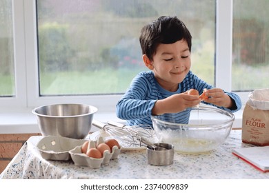 Child broke fresh eggs. Child cracking egg in a glass bowl for cooking baking making cake, waffles, pudding. Child preparing ingredients for healthy family cooking baking concepts portrait . - Powered by Shutterstock