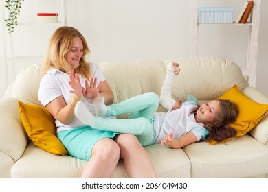 Child With Broken Arm And Gypsum Spend Time At Home With Mother. Childhood Illnesses, A Positive Outlook And Recovery.