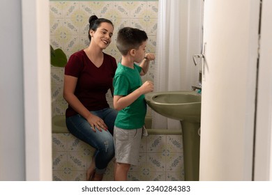 Child brushes teeth and mother accompanies in the bathroom of the house - Powered by Shutterstock