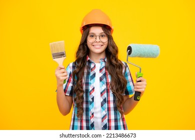 Child Builder In Hard Hat Helmet. Teenage Girl Painter With Painting Brush Tool Or Paint Roller. Teenager Worker Isolated On Yellow Background. Kids Renovation Concept.