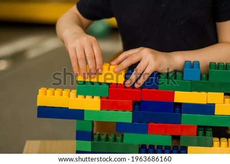 А child building a tower from a constructor. Classes in kindergarten.