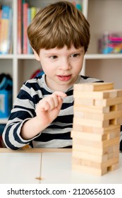 The Child Builds A Tower. Board Game Made Of Wooden Blocks. Develop Your Strategy. Children's Activities. Logical Tasks For Children. Concentration And Attention, Patience, Montessori Methodology. 