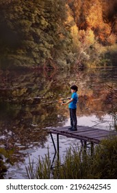 A Child By The River With A Fishing Rod. A Boy On A Fishing Trip.