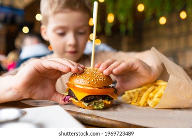 a child in a cafe eats a mini burger with fries. children's menu