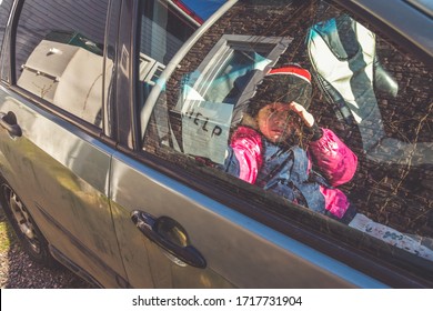 The Child In The Car Holds A Note With The Word Help