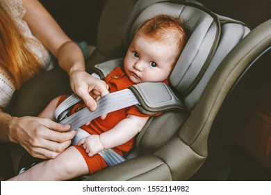 Child In Car Mother Putting Baby In Safety Car Seat Family Road Trip Vacations Lifestyle Child Care Transportation Rear-facing 