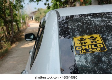 Child In Car Sticker Sign On The Rear Of The White Dirty Car