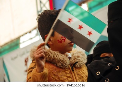 A child carrying the flag of the Syrian revolution. The Syrian revolution against the regime of President Bashar al-Assad. The conflict in Syria. Rebellion.
Aleppo, Syria March 16, 2021