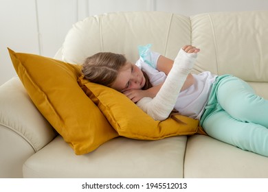 Child With A Cast On A Broken Wrist Or Arm Lying On A Couch. Recovery And Kid Concept.