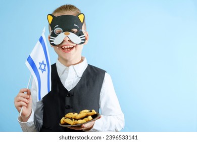 A child in a cat mask holding the flag of Israel on the background of lights. Purim celebration concept. Jewish carnival holiday. High quality photo - Shutterstock ID 2396533141