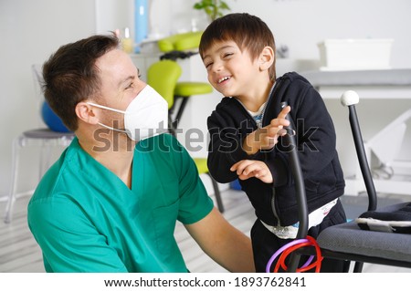Child with cerebral palsy on physiotherapy in a children therapy center. Boy with disability doing exercises with physiotherapists in rehabitation centre. High quality photo.