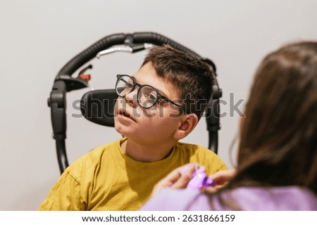 Child with cerebral palsy using visual stimulation device with therapist