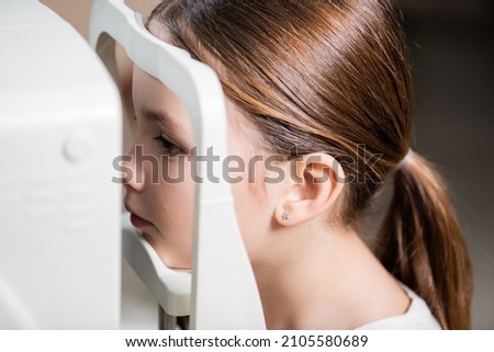 child checking eyesight on blurred vision screener
