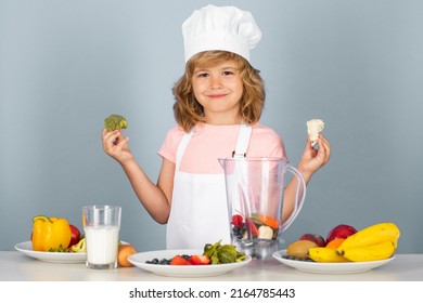 Child Chef Cook Hold Broccoli Prepares Food On Isolated Grey Studio Background. Kids Cooking. Teen Boy With Apron And Chef Hat Preparing A Healthy Vegetables Meal In The Kitchen.