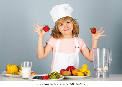 Child Chef Cook Hold Strawberries Prepares Food On Isolated Grey Studio Background. Kids Cooking. Teen Boy With Apron And Chef Hat Preparing A Healthy Vegetables Meal In The Kitchen.