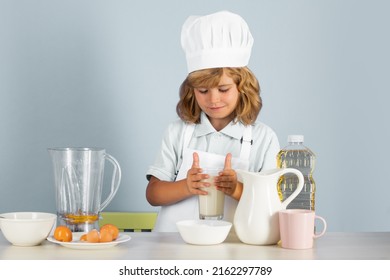 Child Chef Cook Prepares Food On Isolated Grey Studio Background. Kids Cooking. Teen Boy With Apron And Chef Hat Preparing A Healthy Vegetables Meal In The Kitchen.