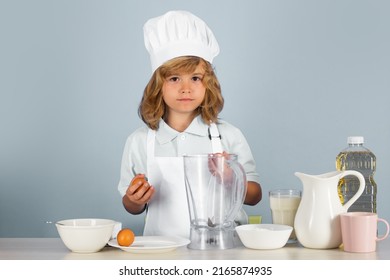 Child Chef Cook Prepares Food On Isolated Grey Studio Background. Kids Cooking. Teen Boy With Apron And Chef Hat Preparing A Healthy Vegetables Meal In The Kitchen.