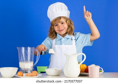 Child Chef Cook Prepares Food With Flour In Isolated Blue Studio Background. Kids Cooking. Teen Boy With Apron And Chef Hat Preparing A Healthy Vegetables Meal In The Kitchen.