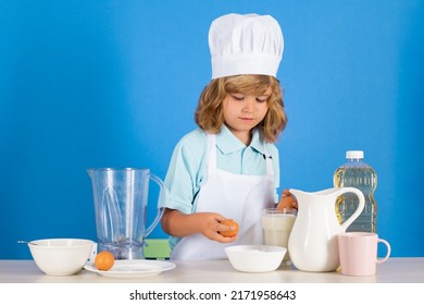 Child Chef Cook Prepares Food In Isolated Blue Studio Background. Kids Cooking. Teen Boy With Apron And Chef Hat Preparing A Healthy Vegetables Meal In The Kitchen.