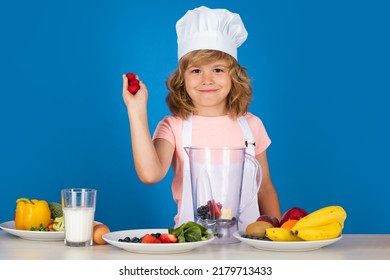 Child Chef Cook Prepares Raspberry Smoothie In Isolated Blue Studio Background. Kids Cooking. Teen Boy With Apron And Chef Hat Preparing A Healthy Vegetables Meal In The Kitchen.