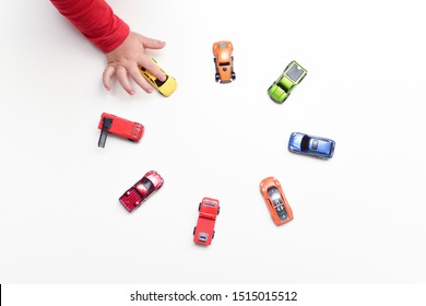 Child Chooses His Favourite Toy Car From Selection Of Toys