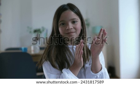 Child clapping hands, one small girl showing congratulations