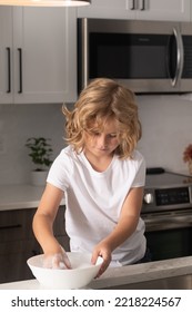 Child Cleaning Dishes With Sponge. Cleaning Supplies. Help Clean-up. Housekeeping Duties. Kid Wash Dishes. A Little Cute Boy Washing Dishes Near Sink In Kitchen.