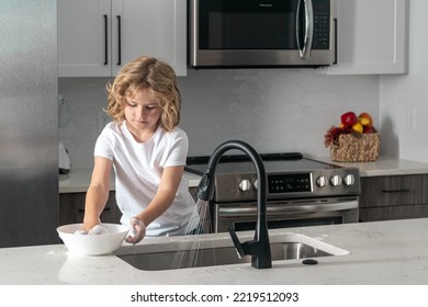 Child Cleaning Dishes With Sponge. Cleaning Supplies. Help Clean-up. Housekeeping Duties. Kid Wash Dishes. Child Help In Washing Dishes At Kitchen.