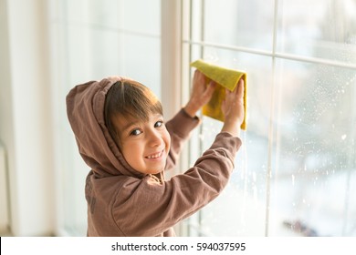 Child Cleaning House Window