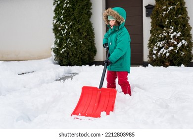 Child Clearing Sidewalks And Shoveling Snow. Girl Removaling Snow With  Shovel. Little Helper For Parents. Winter Kids Fun Outdoor Sports