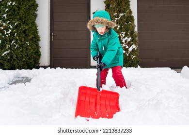 Child Clearing Sidewalks And Shoveling Snow. Girl Removaling Snow With Shovel. Little Helper For Parents. Winter Kids Fun Outdoor Sports