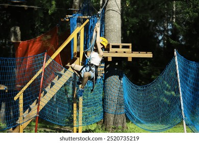 Child Climbing High Ropes Course in Outdoor Adventure Park - Powered by Shutterstock