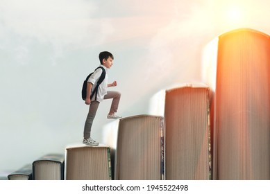 Child climbing stairs made of on sky background. Education or hard study concept. Soft focus - Shutterstock ID 1945522498
