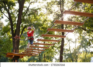 child climbs in a rope park. Boy In Adventure Park having fun in high wire park. Toddler Boy On A Ropes Course. Male toddler on zip line. Boy having a fun on Climbing Frame. Boyscout on a tree. Summer - Powered by Shutterstock