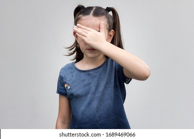 Child closing his eyes with his hand. Confident girl trying to hide her face from other people prefer not to see. Decision, human concept - Shutterstock ID 1689469066