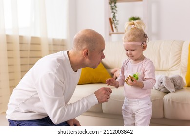 Child With Cochlear Implants Having Fun With Father At Home. Deafness And Medical Technology Concept.