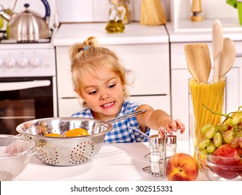 Child With Colander Cooking Dough At Home Kitchen.