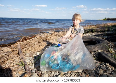 Child Collecting Rubbish On The Bank Of River