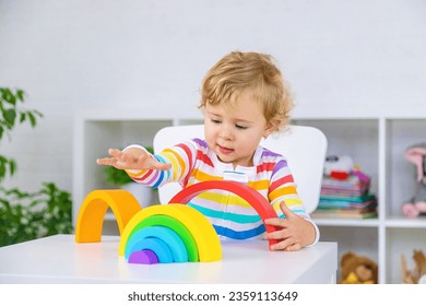 The child collects the constructor rainbow. Selective focus. Kid.