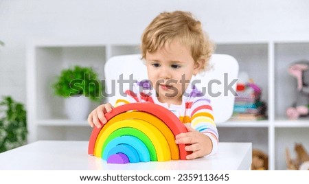 The child collects the constructor rainbow. Selective focus. Kid.
