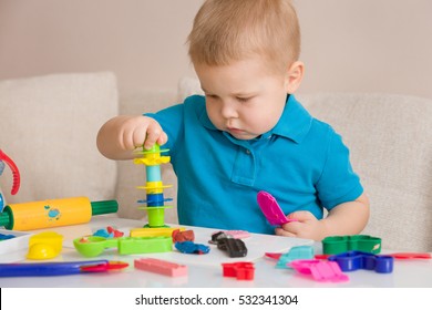 Child With Colorful Clay. Toddler Playing And Creating Toys From Play Dough. Boy Molding Modeling Clay.