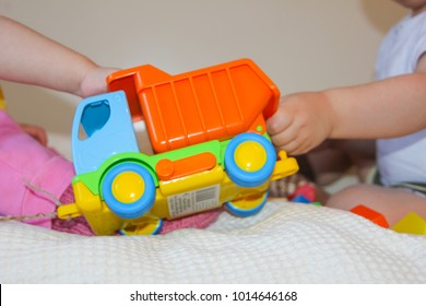 A Child And A Colorful Typewriter. Children Take The Toy From Each Other. They Can Not Share A Machine, Pull It In Different Directions.