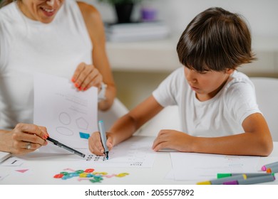 Child Coloring Shapes In A Preschool Assessment Test.