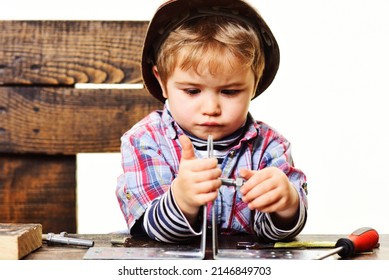 Child connects metal plates parts with bolt. Repair concept. Boy in workshop connecting steel plate.