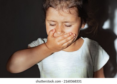 The Child Coughs And Covers His Mouth With His Hand, The Preschooler Is Sad From The Disease