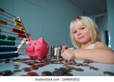 Child Counting Coins And Saving Money, Girl Put Coins Into Piggy Bank