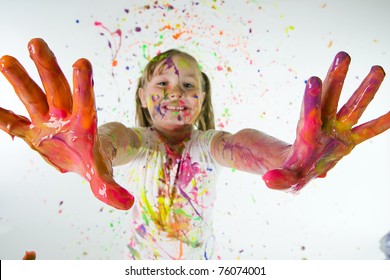 Child Covered In Colorful Paint Showing Her Hands